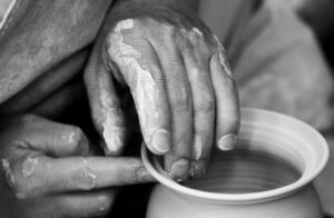Hands making pottery